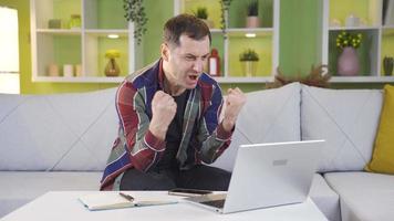 The man who started to laugh, very happy with the news he saw on the laptop screen. After receiving the news he wanted and expected, the man continued his work with a cheerful and smiling. video