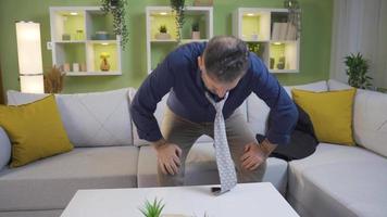 Mature businessman coming home tired and exhausted with a headache. Office worker man who is tired and overwhelmed with work is resting at home, he is not feeling well, he has physical pains. video