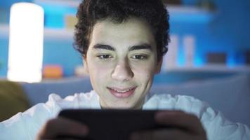 Jugendlicher männlich Aufpassen Videos auf Smartphone allein beim heim. Videos mit nützlich und interessant Inhalt. Filme.