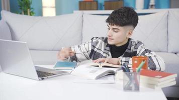 el joven estudiante lo hace no querer a estudiar. aburrido a hogar, el adolescente cierra su cuaderno y lo hace no querer a estudiar. video