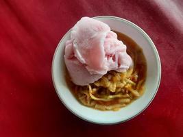 a rujak or spicy fruit salad dish topped with strawberry ice cream photo