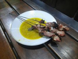 klatak satay made from young goat meat, served with yellow curry soup photo