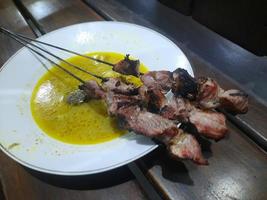 klatak satay hecho desde joven cabra carne, servido con amarillo curry sopa foto