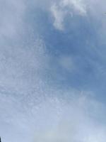 Beautiful white clouds on deep blue sky background. Large bright soft fluffy clouds are cover the entire blue sky. photo