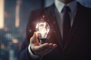 Hand of businessman holding illuminated light bulb, idea, innovation and inspiration concept. . photo