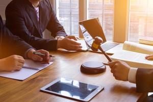 equipo de abogados teniendo legal discusión participación jueces mazo en su manos a golpe en el de madera teclado. legal consejo para justicia en judicial actas para pureza y justicia de jueces foto