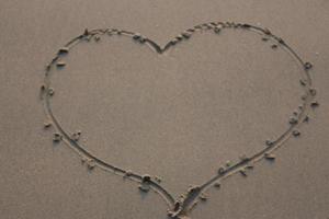 Heart shape on wet sand. Valentine's day background. Love concept. photo