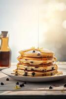 Syrup is poured down and chocolate chips are on top tall stack of golden pancakes layered on a plate with melted butter and syrup dripping down the sides of the stack. . photo