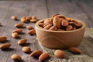 almonds in bowl wood on dark table background photo