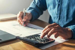 businessman working on desk office with using a calculator to calculate budget, finance concept photo
