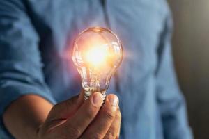 businessman hand holding lightbulb. idea Alternative energy concept saving electricity photo