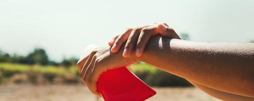 close up young woman applying sunscreen lotion on hand photo