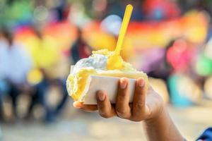 hielo crema en mano mujer con amarillo cuchara en fiesta foto