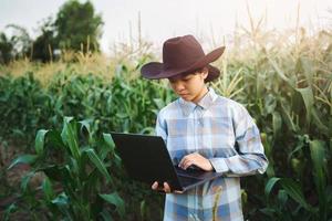 técnico granjero utilizar ordenador portátil computadora comprobación maíz en granja. tecnología agricultura conept foto