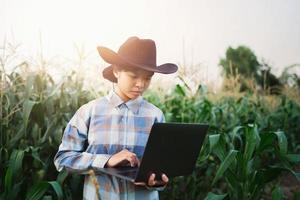 técnico granjero utilizar ordenador portátil computadora comprobación maíz en granja. tecnología agricultura conept foto