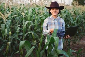 técnico granjero utilizar ordenador portátil computadora comprobación maíz en granja. tecnología agricultura conept foto