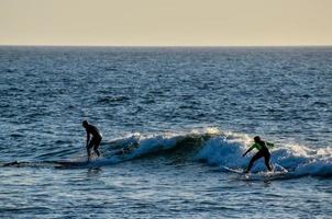 Two surfers catching the wave photo