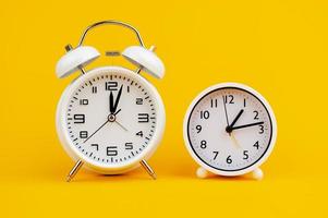 white clock on yellow background concept of time time is important to work photo