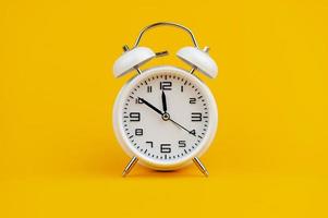 white clock on yellow background concept of time time is important to work photo