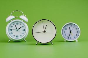 white clock on green background concept of time time is important to work photo