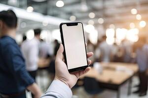 Close up view of hands holding mock up smart phone with modern office blurred background. photo