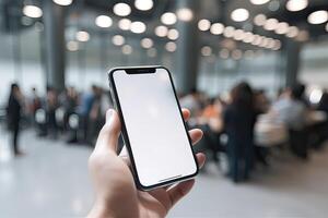 Close up view of hands holding mock up smart phone with modern office blurred background. photo