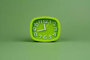 green watch on a green background concept of time Time planning photo