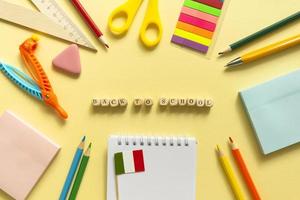 Back to school background. School accessories on a yellow background. Wooden blocks with letters photo