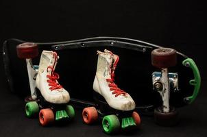 Skate and skateboard on black background photo