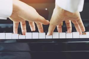 close up of hand people man musician playing piano keyboard with selective focus keys. can be used as a background. photo