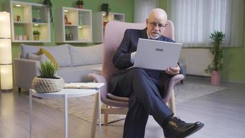 While the man in the suit does his work on the laptop, his naughty grandson scares him. Naughty grandson scaring his grandfather. video