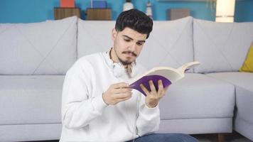 jovem homem lendo uma livro. jovem homem lendo livro confuso e curioso. ele goza isto. video