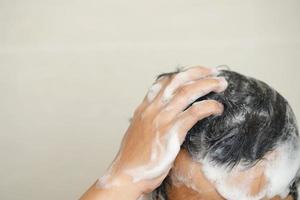 A man is washing his hair with shampoo photo