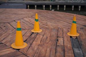 Orange pin for warning hole on the wooden bridge over the lake. The photo is suitable to use for adventure content media, nature poster and forest background.