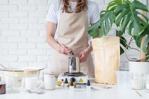 Woman making decorative aroma candle adding aroma, closeup photo