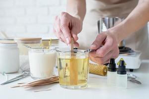 closeup of woman setting the wooden wick into handmade candle photo