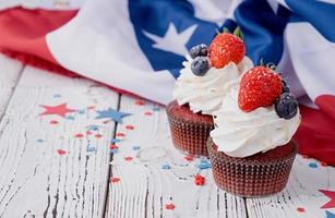 Sweet cupcakes with blueberries and strawberry , flag background photo