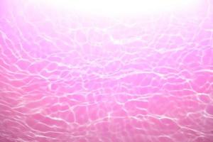 desenfocar borroso transparente rosado de colores claro calma agua superficie textura con chapoteo, burbuja. brillante púrpura agua onda antecedentes. superficie de agua en nadando piscina. púrpura burbuja agua brillar. foto