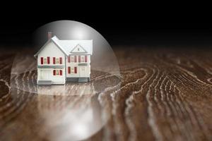 Model House on a Wooden Table Under a Protective Bubble. photo