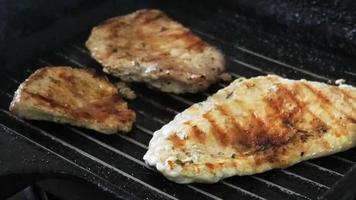 grillen varkensvlees steak Aan de pan. de patroon Aan de steak rookt terwijl grillen. voedsel concept. video