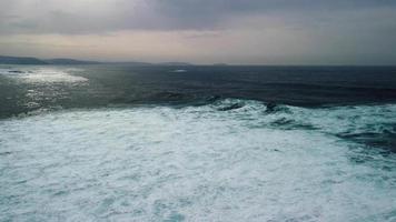 atmosfärisk strand med skummig grov vågor under stormig dag i caion, coruna Spanien. antenn Drönare video