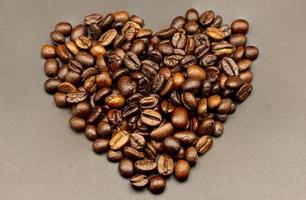 Espresso roasted coffee beans isolated in black background heart close up photo