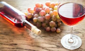 Glass of rose wine with bunch of grape photo