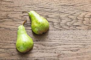 Halves of green pear on the wooden background photo