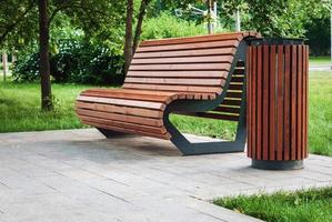 Wooden modern park bench and rubbish bin photo