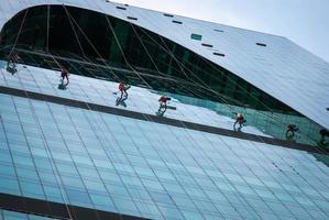 Group of industrial climbers washing glass office building facade, Moscow, 28.07.2020 photo