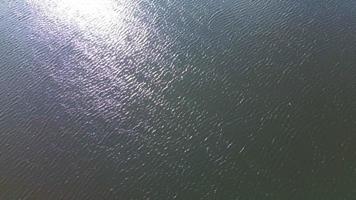 aéreo Visão em espumante água com onda movimento refletindo a brilhante luz solar. video