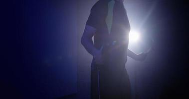 A young man exercising with a skipping rope, training in a dark room video