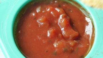 a bowl of chips and salsa on table , video