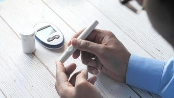 Rear view of man's hand diabetic checking blood sugar level isolated white video